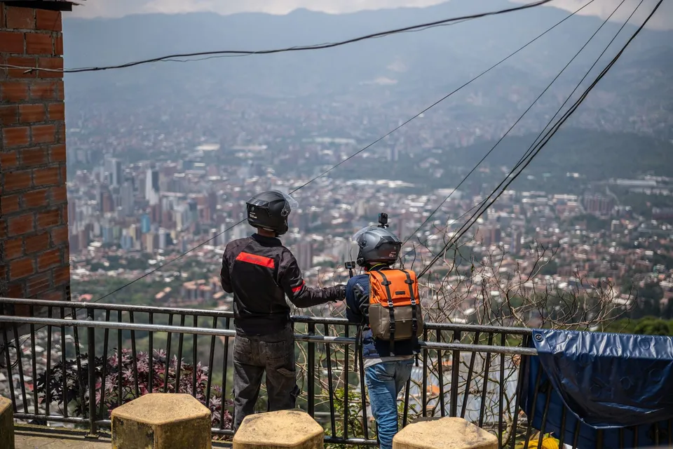 Dos motociclistas mirando la ciudad desde un mirador