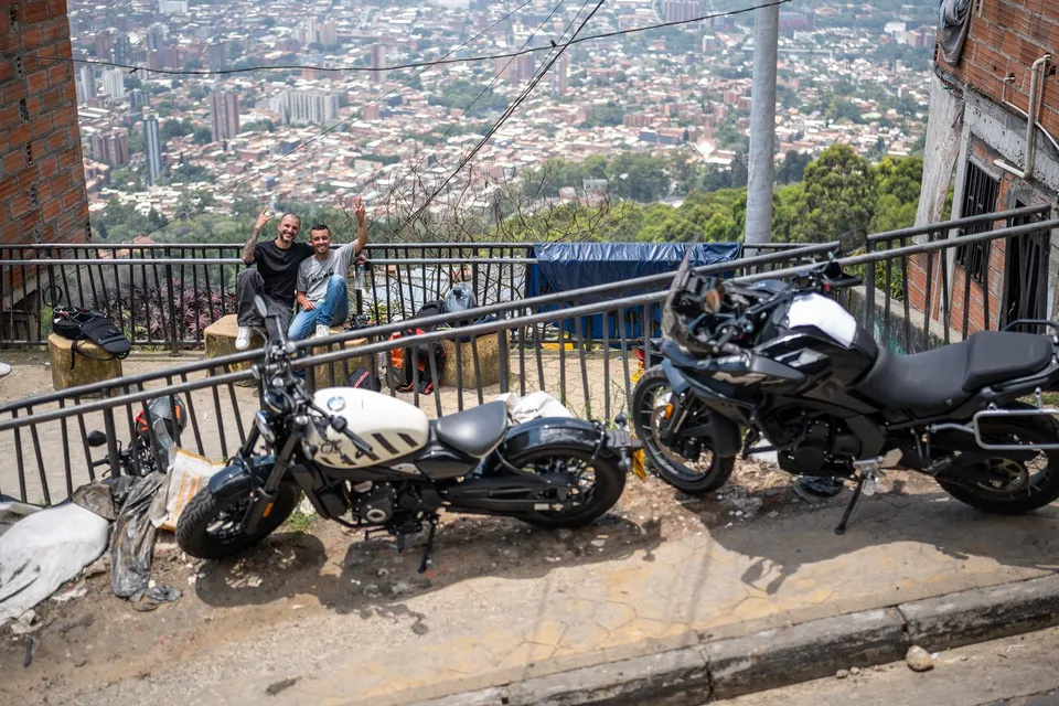 Dos motos parqueadas en un mirador con la ciudad de fondo